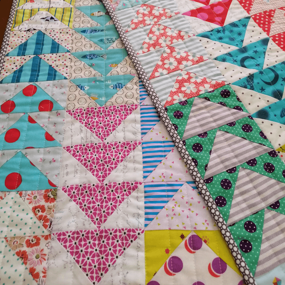 Détail d’un quilt combinant le motif Flying Geese en triangles.